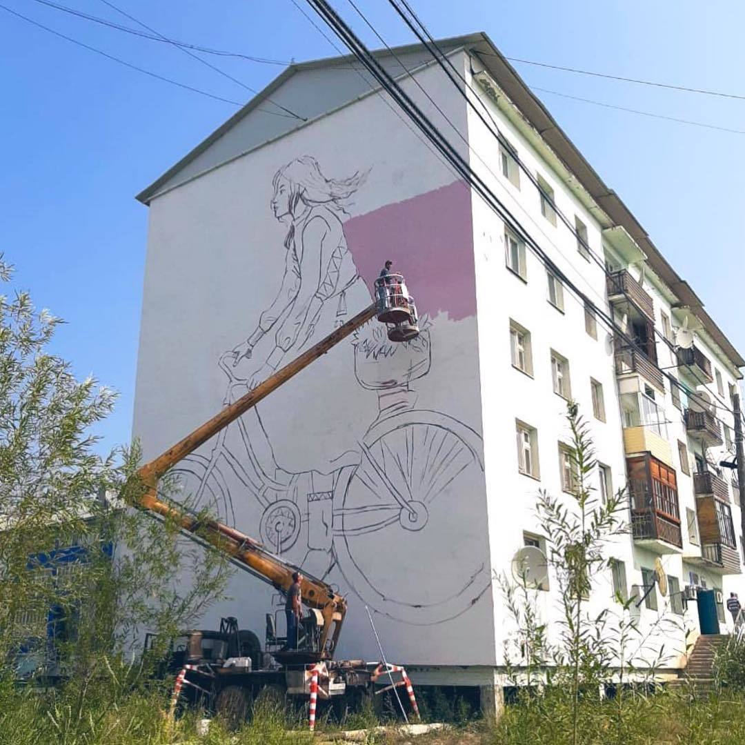 Фотофакт: В Олекминске начали рисовать мурал "Девушка на велосипеде"