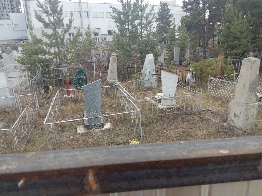 Могилы расположены через забор от кафешек