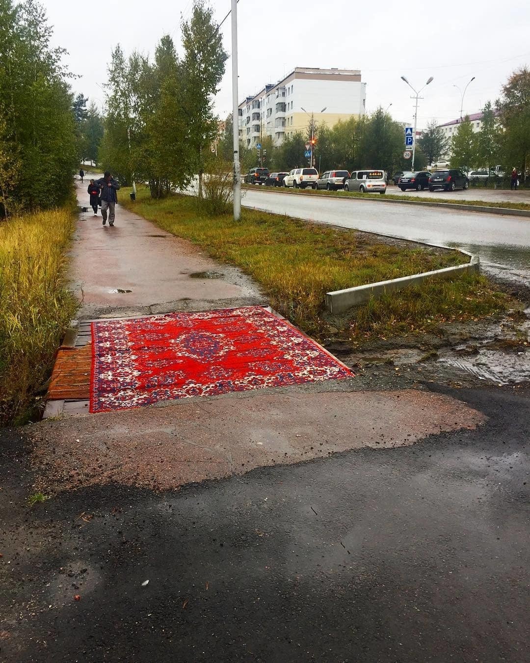 Фотофакт: В Нерюнгри решетку на тротуаре закрыли коврами