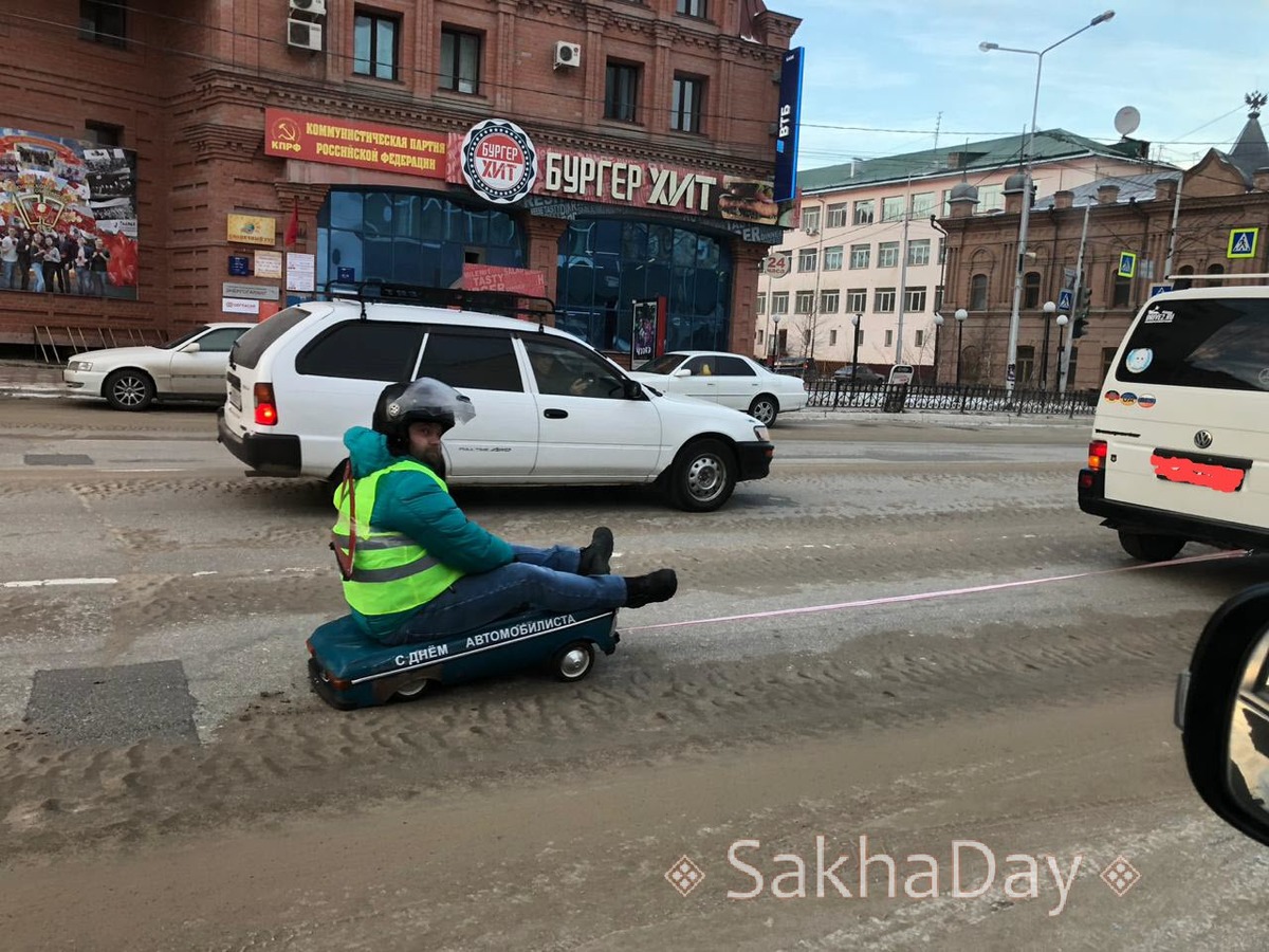Фотофакт: В Якутске мужчина проехался на игрушечном авто с надписью "С днем автомобилиста"